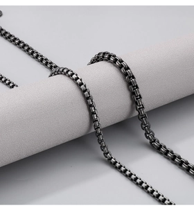 Macro detail of rounded box chain in vintage oxidized titanium steel with high metallic shine