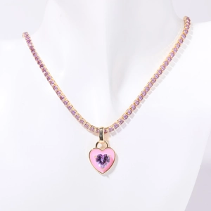 Tennis chain necklace with pink enamel heart pendant and purple zircon stones on a model
