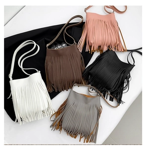Detailed view of the textured leather texture and hanging long tassels on bucket bags