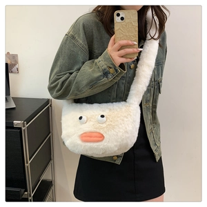 Detail view of a fluffy cream plush crossbody bag featuring funny big eyes and orange lips