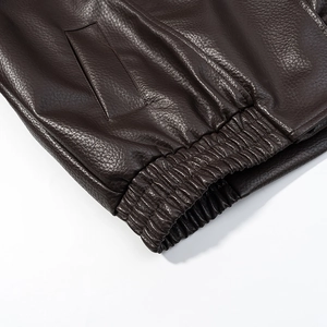 Detailed close-up of dark brown PU leather jacket with elastic cuff and textured finish