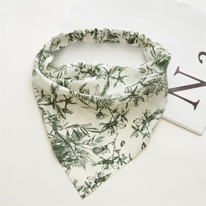 Dettaglio del foulard bianco con stampe di foglie verdi e fascia elastica