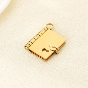 Detail shot of a golden book-shaped pendant with heart cutout and smooth metal finish