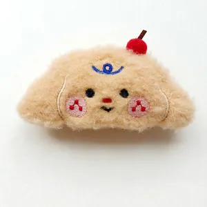 Detail of plush puppy hair clip with cherry embroidery measuring 5.5cm by 11cm