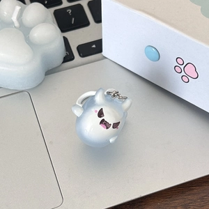 Glow-in-the-dark blue ghost keychain on a laptop with matching aesthetic accessories