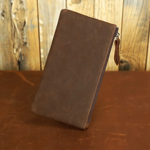 Close-up of vintage brown crazy horse leather wallet with smooth metal zipper detail