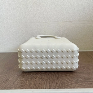 Detail view of the non-slip diamond texture base and air holes of the white EVA beach bag