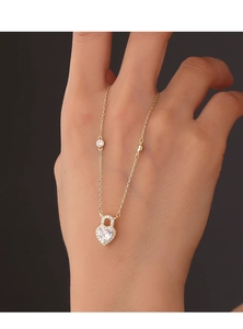 Detail of S925 silver heart padlock necklace with white zircons and gold chain finish