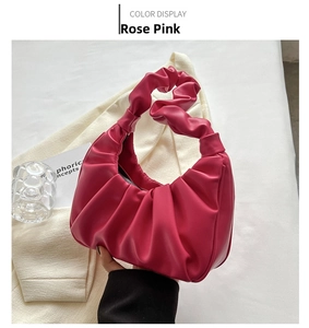 Detailed view of rose pink pleated shoulder bag with knotted handle detail