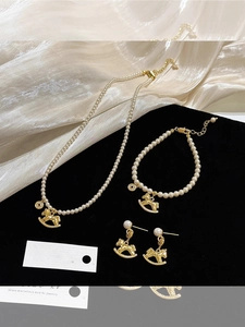 Detailed set featuring pearl necklaces with gold rocking horse and copper coin pendants