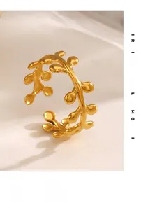 Detail of minimalist gold-plated stainless steel leaf ring on a marble surface