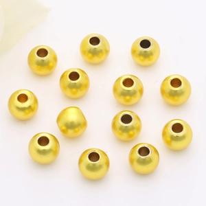Detailed view of thirteen polished 14K gold filled spacer beads on a white background