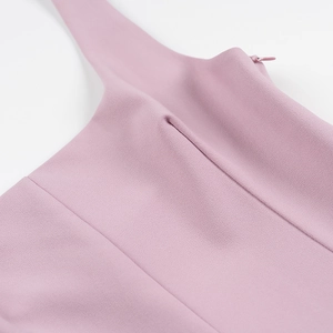 Détail d'une robe plissée rose avec fermeture éclair invisible et tissu tissé lisse