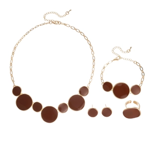 Parure de bijoux dorés avec pendentifs ronds marrons sur fond blanc immaculé