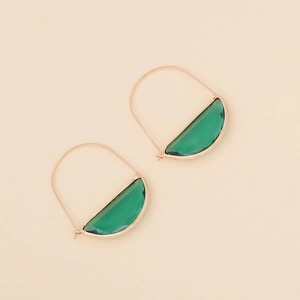 Macro detail of half-moon green glass earrings with textured gold metallic frames