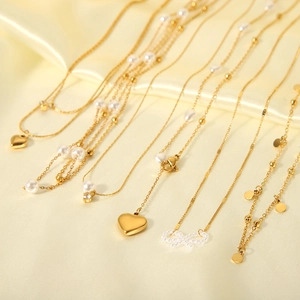 Collection de colliers dorés avec cœur et perles sur un élégant tissu en satin jaune