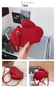 Détail du sac bandoulière rouge en forme de lapin en cuir grainé avec boucles dorées