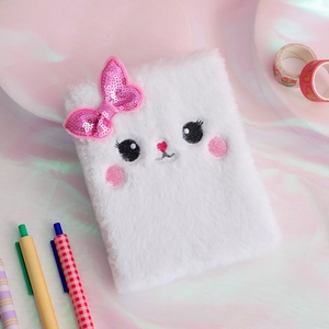Close-up of white plush notebook cover with sequin bow and cute cat face embroidery
