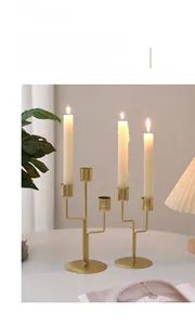 Close-up of golden multi-head metal candle holders with brushed texture on dinner table