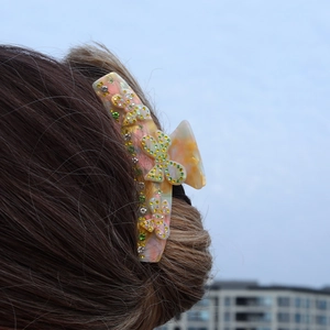 Detail of tortoise shell hair claw clip with crystal butterflies on a bun hairstyle