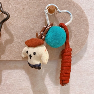 Detail of fabric mushroom pendant with brown beret, teal pompom, and heart carabiner