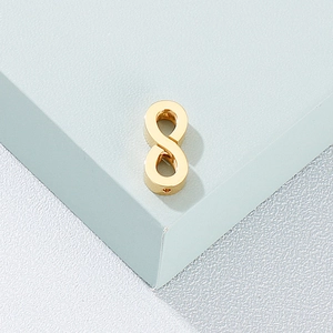 Macro shot of a golden infinity symbol bead in polished stainless steel for jewelry making