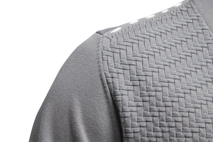 Macro view of grey knit cardigan showing fine stitching and complex woven texture
