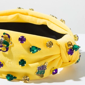 Detailed macro view of yellow Mardi Gras headband with colorful rhinestones and gold emblem