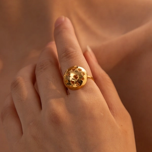 Chic hollow heart dome ring in gold finish on female hand showing artistic design