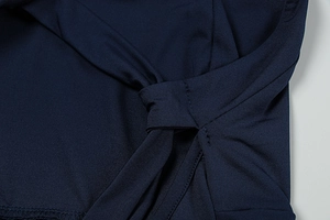 Detailed view of dark blue dress showing precision knotting and smooth seam craftsmanship