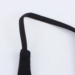 Détail de la fine bretelle noire et du tissu côtelé élastique de la robe dos nu élégante