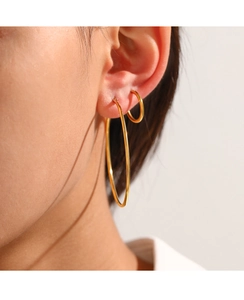 Close-up of minimalist gold hoop earrings set showing stacked style on model ear