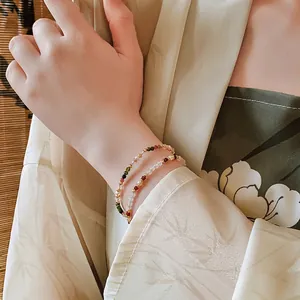 Elegant 18K gold-plated beaded bracelet set with colorful pearls on a female wrist