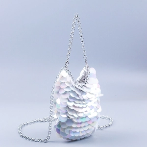Detailed macro view of white iridescent sequins and silver chain strap on the handbag