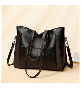 Large black soft leather tote bag with brown stripe detail and removable strap