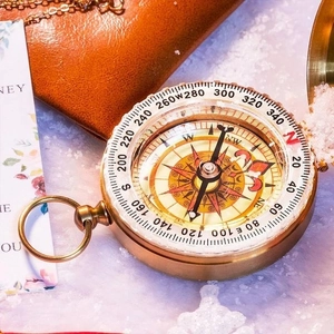 Macro detail of retro brass compass with engraved nautical star and side hanging ring