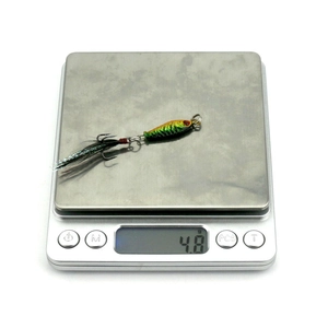Macro view of a 4.8g micro fishing jig lure showing gradient color scale texture