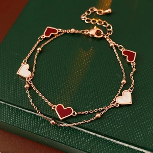 Vue détaillée du bracelet cœur double couche or rose sur un coffret cadeau vert foncé
