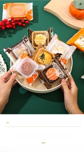 Detail of assorted frosted semi-transparent mooncake bags on a rustic wooden tray