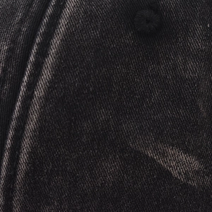 Detailed close-up of washed black fabric texture and stitching on the baseball cap