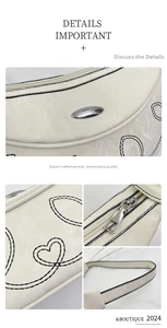 Dettaglio della borsa a mezzaluna beige con motivi a cuore e finiture in metallo argento