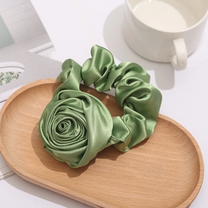 Green satin rose scrunchie on a wooden tray with elegant French vintage style