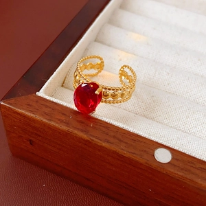 Detail of a vintage oval red gemstone ring in a gold-plated setting on a velvet display