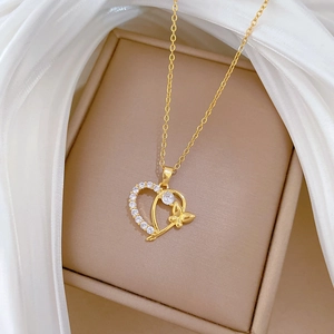 Titanium steel gold necklace with heart and butterfly pendant on white silk background