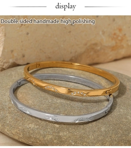 Close-up of gold and silver stainless steel bangles with sparkling zircon inlay