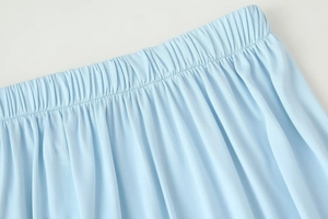 Detail of light blue high-waisted skirt featuring elastic waistband and knitted texture