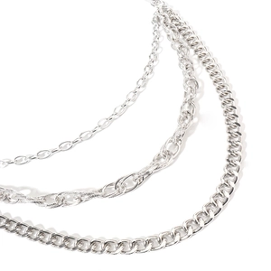 Close-up of multi-layer silver metal trouser chains featuring a classic Cuban link design