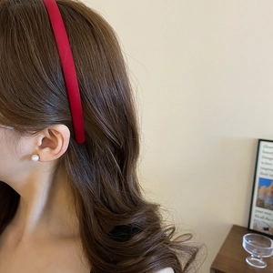 Close-up of elegant red velvet headband and round white pearl earrings on female model