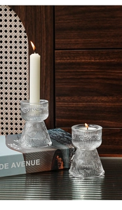 Close-up of vintage ribbed glass candle holders with elegant embossed texture and warm glow