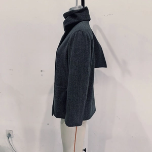 Detail of dark grey wool coat featuring large side pockets and textured fabric
